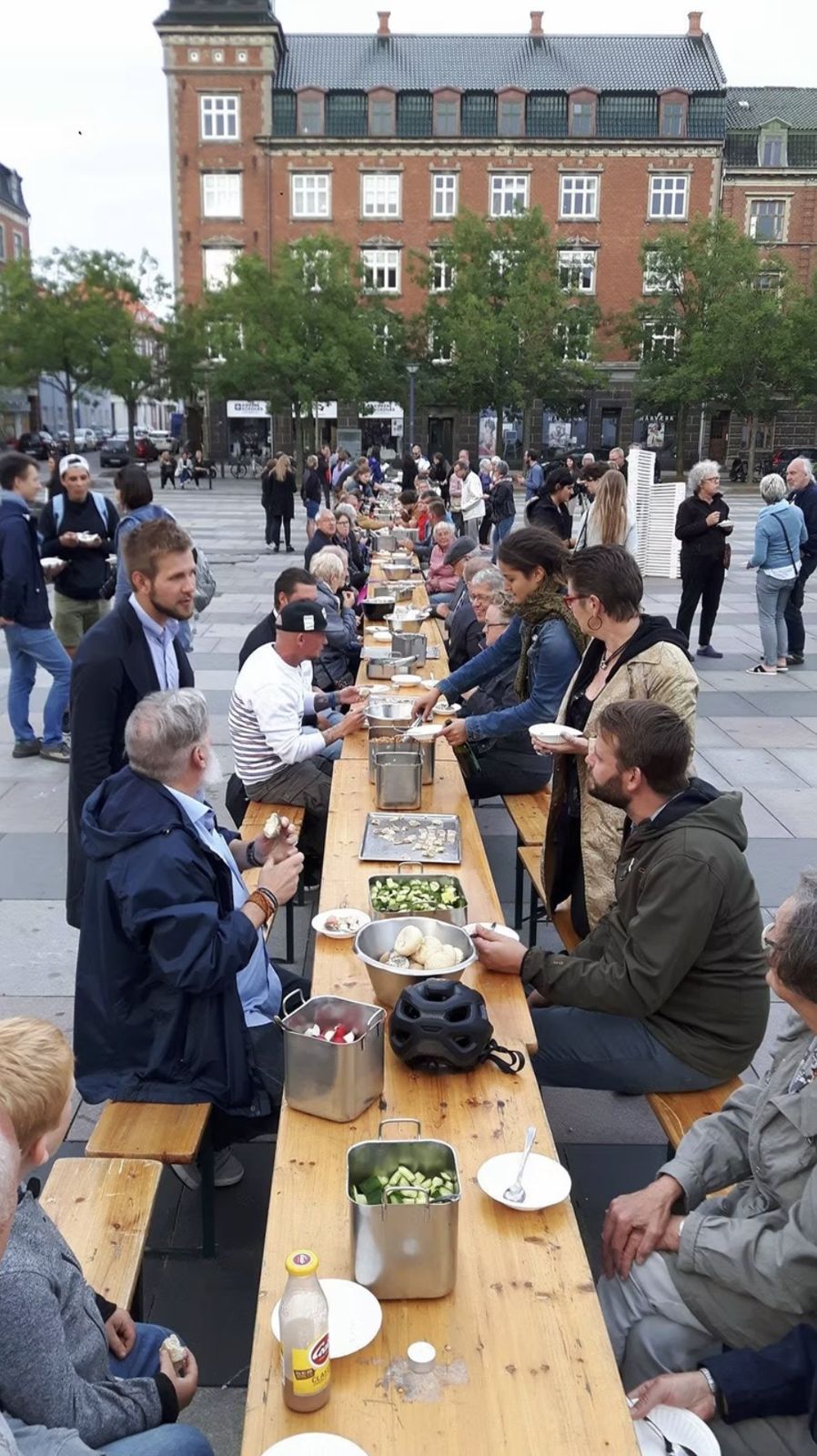 Babette’s Town Feast: a long communal table set with pots and bowls on the town square