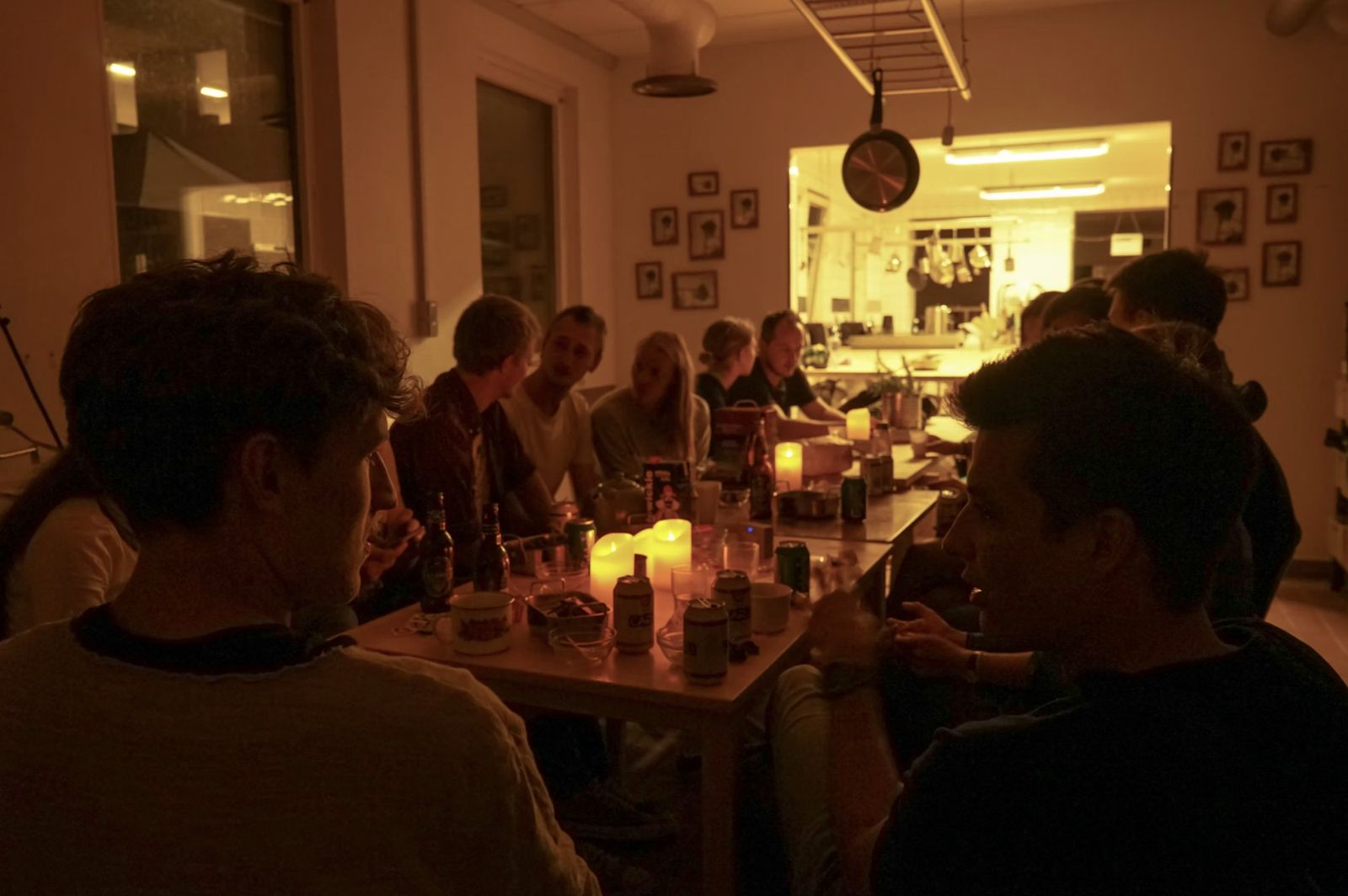 Neighbours sharing drinks by candlelight at a long table in the Fredericia Food Lab