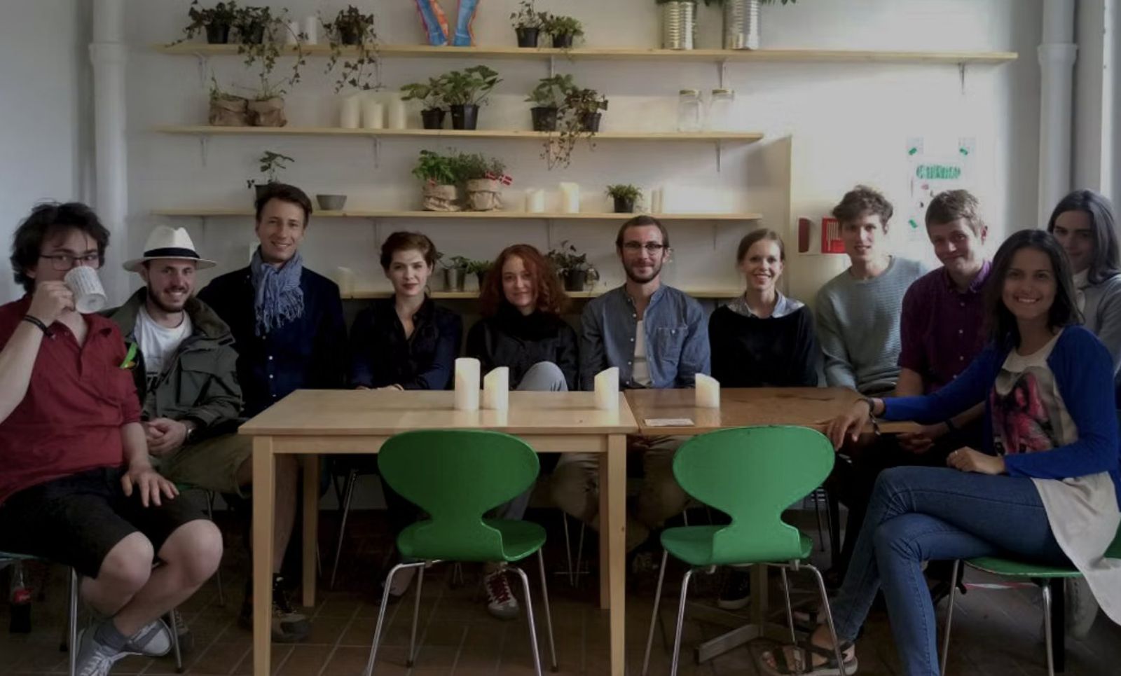 The Fredericia Food Lab team seated together in front of shelves of plants